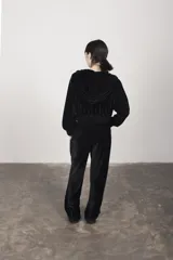 Campera negra de terciopelo con capucha doble, cierre frontal, dos bolsillos y frunce en puños y cintura.