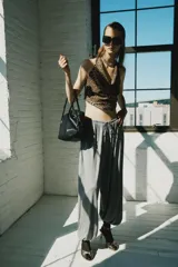 Top halter de cuello fluido y bajo asimétrico, con estampado animal print tipo leopardo y cierre de lazos en la espalda.