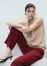 Pantalón de vestir color bordó, de tiro medio y diseño recto con pinzas delanteras. Cuenta con trabillas para cinturón, bolsillos laterales y cierre oculto con botón, gancho y cremallera.