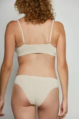 Top de estilo deportivo confeccionado en tejido seamless, con breteles finos y escote redondeado. Presenta un diseño minimalista y ajustado con el logo de la marca estampado en el bajo busto.