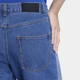 Pantalón de jean Adidas modelo Firebird, de corte recto y tiro medio. Presenta las icónicas tres franjas laterales en color blanco y cierre frontal con botón y cremallera.