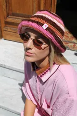 Gorro tipo bucket tejido al crochet con rayas horizontales en colores celeste, marrón, naranja y rojo.