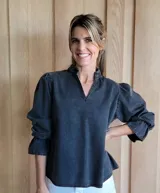 Blusa de algodón con cuello mao y volados, mangas largas con puños elásticos y corte holgado.