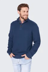 Buzo gris de tejido grueso con cuello alto y medio cierre con botones.