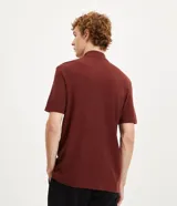 Remera de manga corta color bordó, con cuello redondo y cierre frontal.