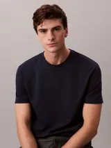 Remera de corte regular confeccionada en algodón, con cuello redondo y mangas cortas. Presenta un diseño minimalista con el logo de la marca sutilmente bordado en el pecho.