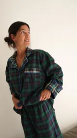 Conjunto de pijama a cuadros con ribetes en color lila, compuesto por camisa de manga larga con botones y pantalón largo.