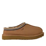 Zuecos UGG modelo Tasman II, confeccionados en gamuza color marrón con forro interno de piel de oveja. Presentan un ribete trenzado decorativo en el cuello y suela de goma resistente.