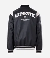 Campera bomber de cuero sintético con diseño bicolor, cuerpo negro y mangas blancas. Presenta cuello, puños y cintura con tejido elástico a rayas, cierre frontal con botones a presión y bordado con la palabra Authentic en el pecho.