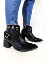 Bota tejana de cuero, combinada en color tostado, animal print de leopardo y puntera en charol negro. Cuenta con taco de madera, detalle de hebilla lateral y ojales metálicos en la parte superior.