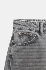 Jeans de tiro medio con corte cropped y diseño de costuras torcidas. Presenta trabillas en la cintura, cinco bolsillos clásicos y cierre frontal con cremallera y botón metálico.