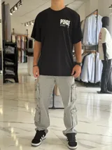 Remera oversize blanca de manga corta, con gran estampado negro en la espalda con la palabra 'Peace' y símbolos gráficos.