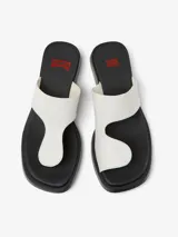 Sandalias de cuero vacuno color blanco, con tira ancha sobre el empeine y tira entre los dedos. Suela plana color negro.