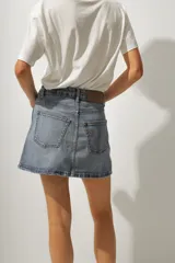 Minifalda de jean color negro con lavado gastado, corte recto y tiro alto.