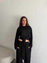 Conjunto de dos piezas de viscosa y poliéster color gris melange, compuesto por un buzo de manga larga y un pantalón largo de corte recto con lazo ajustable en la cintura.