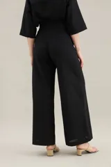 Pantalon largo de lino color tostado, tiro alto, corte ancho y recto, con costuras centrales decorativas y bolsillos laterales.