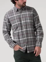 Camisa de franela a cuadros de algodón orgánico color gris, con dos bolsillos frontales, cierre de botones y cuello camisero.