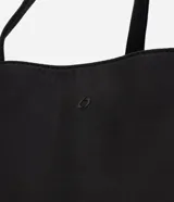 Cartera tipo shopper grande de Satinato en color negro, confeccionada en poliéster con estructura amplia y laterales expandibles. Cuenta con asas dobles de cinta reforzada, cierre superior y bolsillos con cierre.