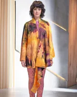 Capa asimétrica multicolor de lana merino afieltrada, teñida artesanalmente con acuarelas en tonos amarillos, naranjas, azules y violetas.