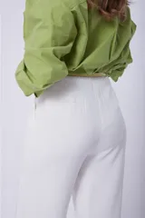 Camisa verde de mangas largas abullonadas, con cuello clásico y cierre frontal con botones.