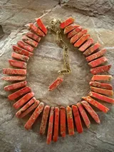 Collar de piedras de jaspe natural en tonos naranja y coral, con cadena de extensión metálica dorada.