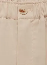 Pantalon de corte wideleg color beige, con cintura elástica, cierre frontal de cremallera y botón, y detalle de pliegues frontales.