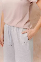 Pantalón gris melange de calce relajado y pierna amplia, con cintura elastizada y cordón regulable. Cuenta con bolsillos laterales y tejido de tacto suave.