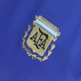 Remera de fútbol Adidas Originals de la selección argentina, de color azul con cuello redondo blanco y las clásicas tres tiras blancas en las mangas. Cuenta con el logo del trifolio de Adidas bordado en blanco y el escudo de la AFA en el pecho.