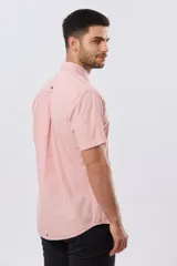 Camisa lisa de algodón azul marino, de manga corta, con cuello camisero, cierre frontal de botones y un bolsillo aplicado en el pecho.