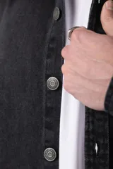 Chaqueta de jean negro desgastado, de corte recto, con cuello clásico, cierre frontal con botones y bolsillo en el pecho. Confeccionada en denim de algodón de 12 onzas.