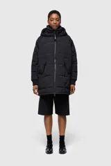 Chaqueta acolchada negra con capucha, cierre frontal con cremallera, bolsillos laterales y puños ajustados.