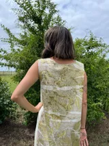 Vestido midi de corte evasé con estampado de hojas en tonos verdes y beige.