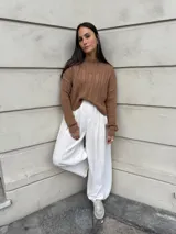 Sweater color crema tejido con diseño en ochos y cuello redondo.