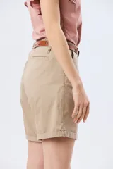 Bermuda clásica de corte recto, confeccionada en algodón con elastano, con bolsillos laterales y vuelta en el ruedo. Incluye un cinturón delgado de cuero marrón.