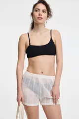 Short blanco de tejido calado, con cintura elástica y diseño transparente.