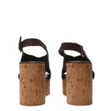 Sandalias de plataforma alta tipo cuña con acabado de corcho. Presentan tiras cruzadas en el empeine confeccionadas en gamuza color beige y una pulsera ajustable con hebilla metálica en el tobillo.