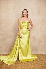 Vestido largo de satén color verde lima, strapless con escote drapeado y tajo delantero con una larga cola lateral.