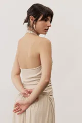 Top negro con diseño cruzado tipo halter, escote pronunciado y fruncido lateral.