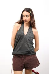 Top de cuello halter con estampado de rayas verticales en tonos granate, beige y mostaza. Confeccionado en tejido elástico, presenta un corte ajustado y diseño sin mangas.