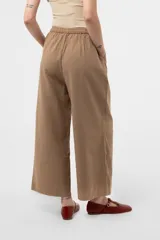 Pantalon de pierna amplia y calce relajado color tostado, con cintura elastizada y lazo regulable.