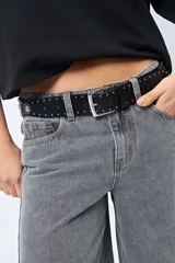 Cinturón marrón con tachas plateadas y hebilla metálica rectangular.