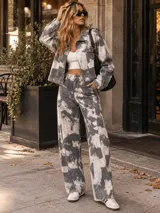 Pantalón jean ancho estilo baggy, de tiro semi alto, con estampa estilo tie-dye en tonos gris y blanco.