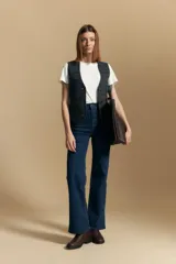 Jean de tiro alto con corte recto, confeccionado en denim con spandex para mayor elasticidad y confort. Presenta un diseño clásico de cinco bolsillos con cierre de botón y cremallera.