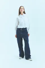Jean de tiro bajo y corte oversize, confeccionado en denim azul con monograma grabado a láser en toda la prenda. Presenta doble botón metálico en la cintura y diseño de cinco bolsillos.