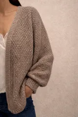 Cardigan de punto abierto con diseño melange, confeccionado en una mezcla de mohair y algodón. Presenta mangas largas con puños acanalados y un corte holgado.