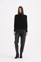 Sweater de cuello alto tipo polera, color negro, con detalle de pespuntes decorativos en color blanco en las mangas y laterales.