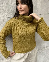 Sweater de punto acanalado color mostaza, con cuello alto tipo polera y diseño corto.