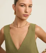 Blusa sin mangas de tejido tipo airflow, con escote en V y breteles anchos. Presenta una textura ligeramente arrugada y costura central vertical decorativa.