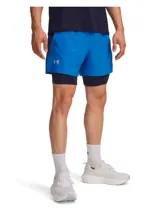 Shorts deportivos Under Armour 2 en 1, compuestos por un short exterior ligero de color azul y un short de compresión interior integrado de color azul marino. Presenta cintura elástica con cordón, bolsillos laterales y logotipo reflectante.