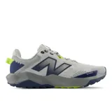 Championes New Balance Nitrel V6 de hombre, color gris con detalles en azul marino y verde flúor, diseñados para trail running y senderismo. Cuenta con capellada de malla transpirable, tecnología DynaSoft en la entresuela y suela AT Tread.